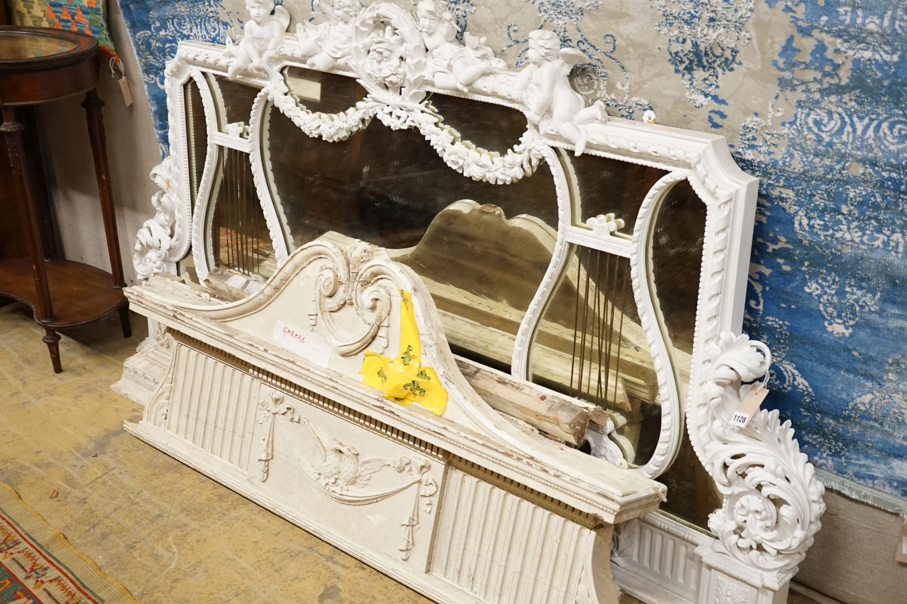 An Edwardian carved wood and gesso overmantel with cherub surmount, later painted white, width 188cm, height 96cm and a two white painted door pediments in need of restoration